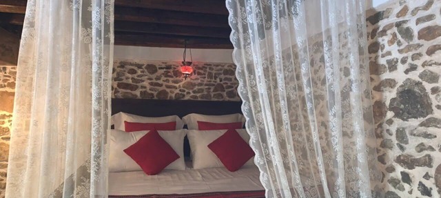 Traditional stone built single room house with traditional bed.